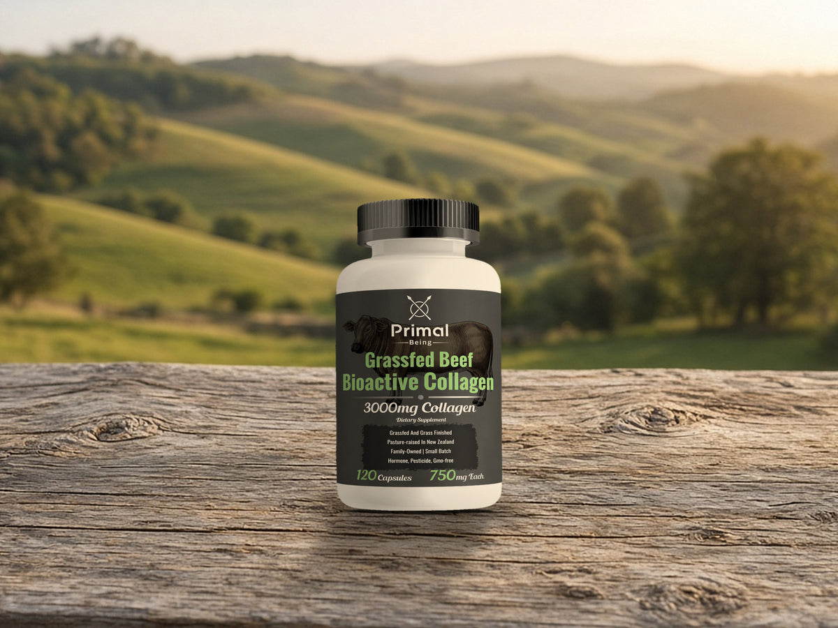 Primal Being Grassfed Beef Bioactive Collagen bottle standing on a weathered wood plank with golden hour pasture hills behind