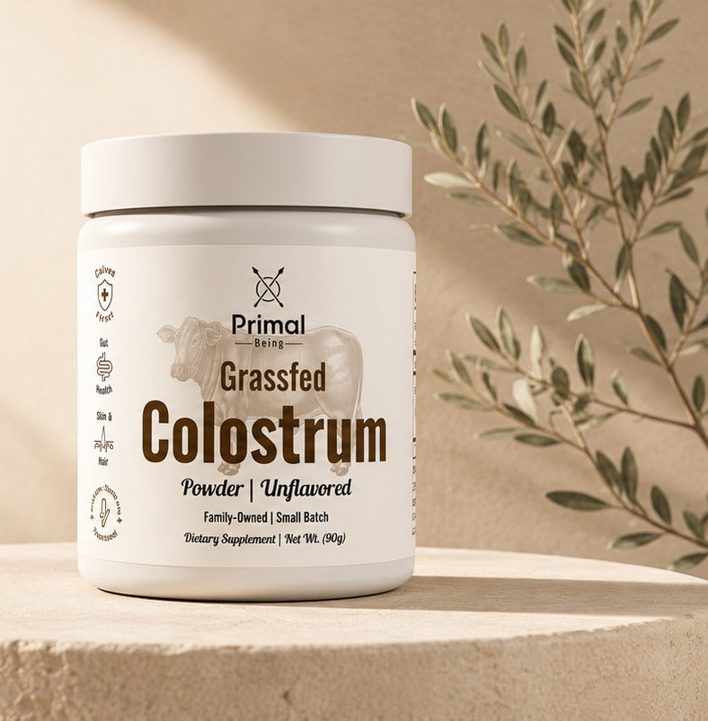 Primal Being Grassfed Colostrum powder jar on a stone plinth